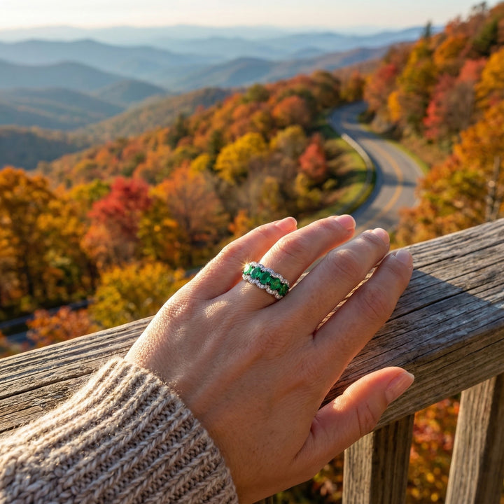 14K White Gold Oval Emerald & Diamond Halo Band This elegant band showcases a row of vivid oval-cut emeralds, each framed by sparkling round diamonds in a soft scalloped halo.