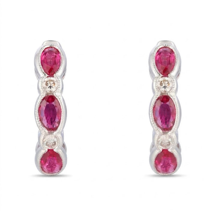 1.56 TOTAL CARAT WEIGHT OVAL RUBY AND .16 TOTAL CARAT WEIGHT ROUND DIAMOND BEZEL HUGGIE EARRINGS IN 14K WHITE GOLD